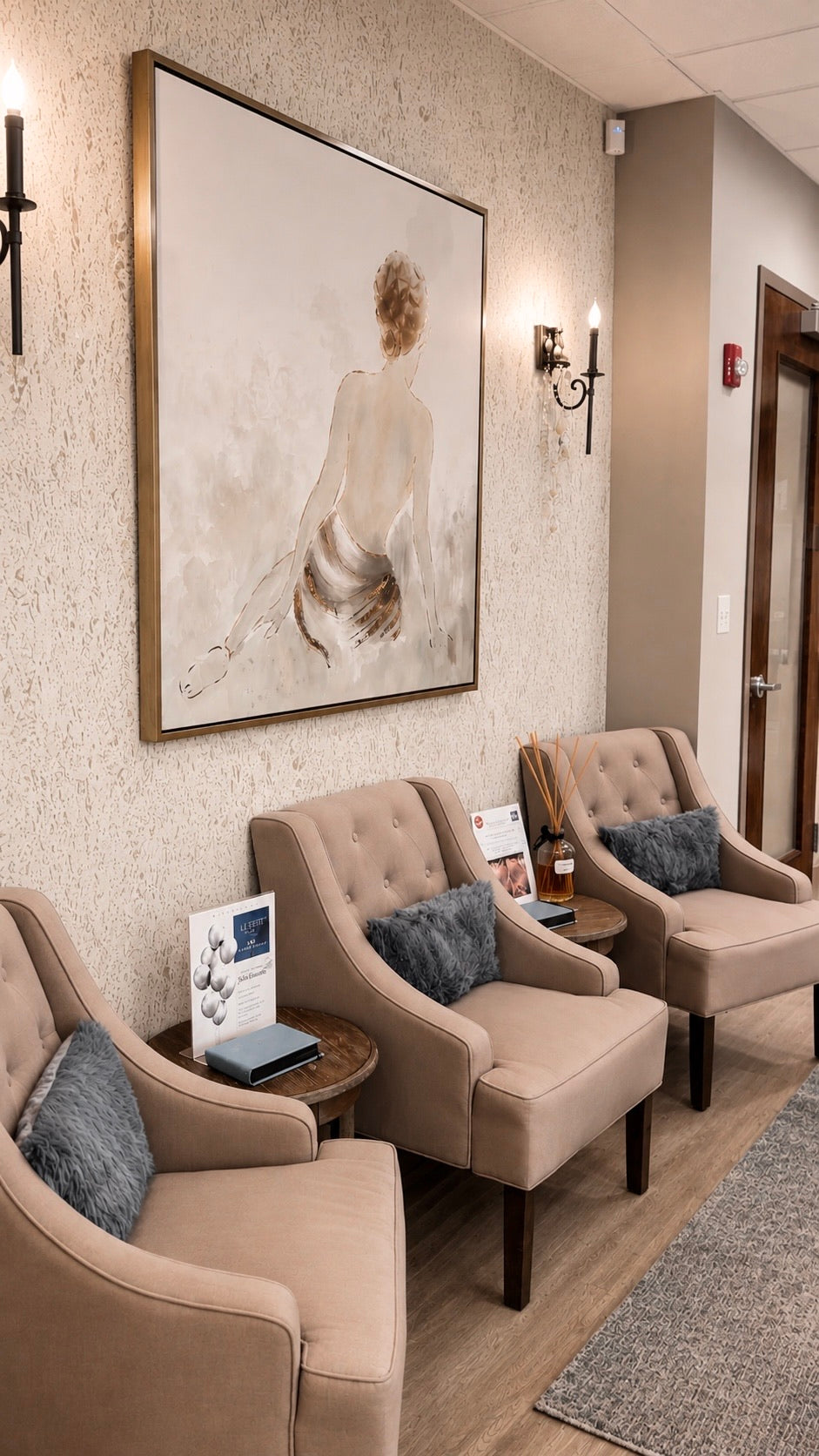 The lounge at Le Petit Spa Ballantyne, three tufted armchairs under a large framed painting between candle sconces