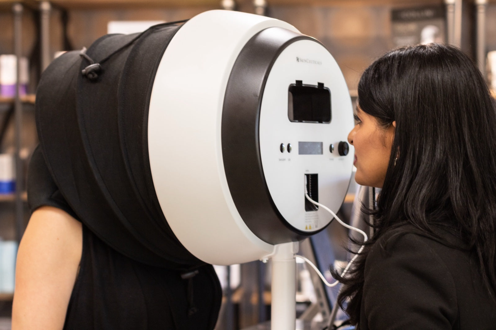 Priti Patel reading a client's skin through a SkinCeuticals skin analysis device at Le Petit Spa SouthPark